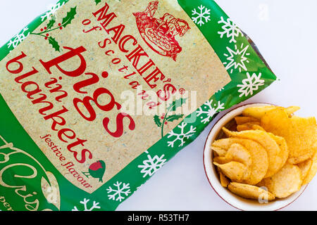 Öffnen Paket von Mackie's von Schottland Schweine in Decken festlichen Geschmack Kartoffelchips mit Chips in der Schüssel auf weißem Hintergrund - bereit für Weihnachten Stockfoto