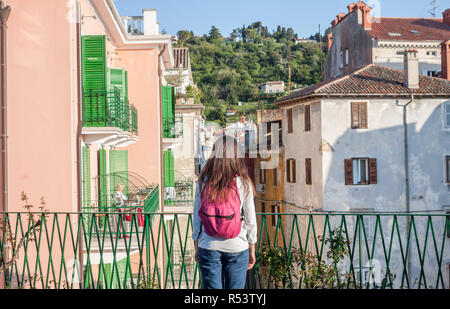 junge Frau sieht vom Balkon auf Italienisch Straße Stockfoto