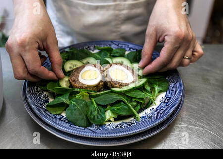 Scotch Egg mit Spinat und Gurkensalat Stockfoto
