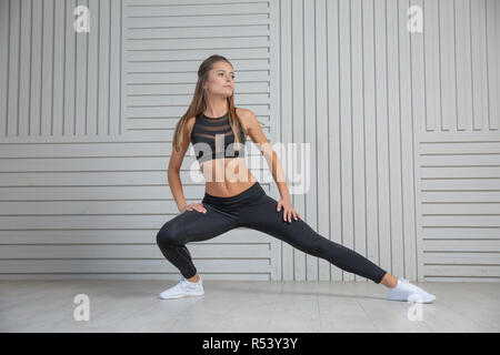 Schöne junge Frau Übungen auf dem Boden, ihre Muskeln zu stärken, Gesundheit Konzept Stockfoto