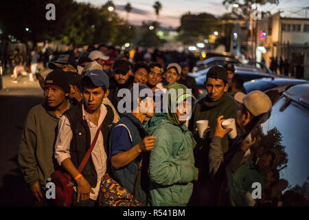 Tijuana, Mexiko. 28 Nov, 2018. Migrantinnen und Migranten sind Schlange zu einem Essen. Dutzende von Migrantinnen aus Mittelamerika haben freiwillig aus Mexiko in ihre Heimatländer zurückgekehrt, nach etwa zwei Wochen an der US-Grenze. Credit: Omar Martinez/dpa/Alamy leben Nachrichten Stockfoto