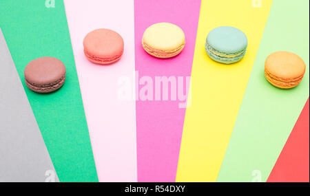 Bunte macarons Kuchen. Kleine Kuchen. Süß und bunt französische Makronen auf farbigen Hintergrund, Hohe Betrachtungswinkel mit Kopie Raum Stockfoto