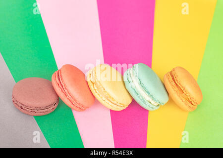 Bunte macarons Kuchen. Kleine Kuchen. Süß und bunt französische Makronen auf farbigen Hintergrund, hohe Betrachtungswinkel mit Kopie Raum Stockfoto