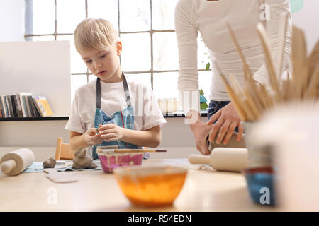 Keramik Kurs für Kinder. Der junge Kratzen aus einem Kunststoff Workshop ist. Stockfoto