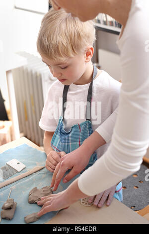 Keramik Kurs für Kinder. Der junge Kratzen aus einem Kunststoff Workshop ist. Stockfoto