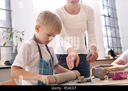 Keramik Kurs für Kinder. Der junge Kratzen aus einem Kunststoff Workshop ist. Stockfoto