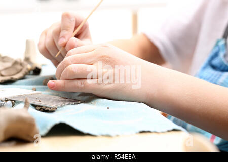 Keramik Kurs für Kinder. Der junge Kratzen aus einem Kunststoff Workshop ist. Stockfoto