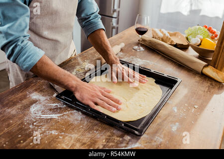 7/8 Schuß des Menschen Vorbereitung Pizza Teig auf Backblech Stockfoto