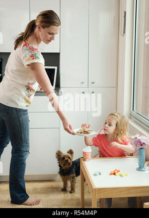 Eine Mutter ihrer Tochter geben einen Snack am Nachmittag. Stockfoto