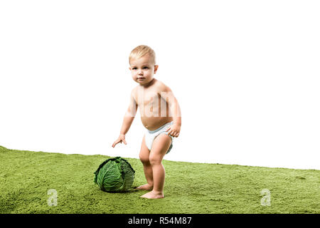 Kleinkind Junge mit großen Kohl auf grünen Teppich isoliert auf weißem Stockfoto