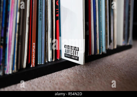 Parental Advisory Label auf Vinyl record Sleeve unter den Stapel der Datensätze im Regal Stockfoto