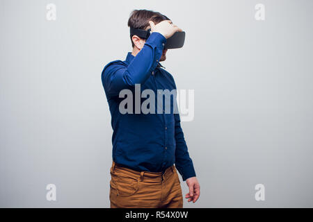 Junger Mann mit VR-Brille Headset versucht, Objekte in der Virtuellen Realität zu berühren. Isoliert weißer Hintergrund. Stockfoto