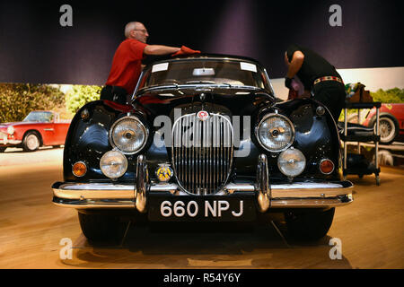 Die Assistenten des Auktionshauses polieren einen Jaguar XK150 'S' aus dem Jahr 1960 während eines Fotoaufrufs für Supersportwagen im Wert von 20 Mio. £, bevor sie bei einer Auktion in Bonhams in der New Bond Street, London, angeboten werden. Stockfoto