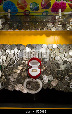 10 Pence 10 p Münzen warten zu fallen und (gewonnen oder verloren werden und an die Arcade Inhaber gehen) in einem traditionellen Coin Pusher/drücken, Münzen Spiel an einer Pier Fun House Arcade. UK. (98). Stockfoto