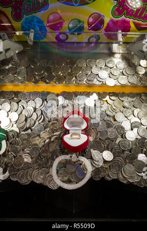 10 Pence 10 p Münzen warten zu fallen und (gewonnen oder verloren werden und an die Arcade Inhaber gehen) in einem traditionellen Coin Pusher/drücken, Münzen Spiel an einer Pier Fun House Arcade. UK. (98). Stockfoto