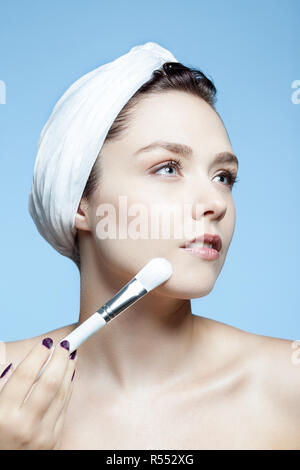 Porträt einer Frau mit einem Make-up-Pinsel auf ihrem Gesicht Stockfoto