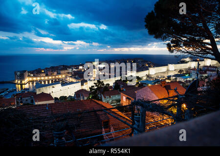 Dubrovnik Antenne Nacht Blick über Altstadt und Dächer nach Sonnenuntergang mit beleuchteten Festung Wand- und dramatische cloudscape, Kroatien Stockfoto