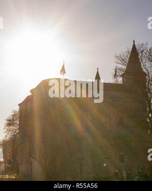 Brügge, Belgien - 17. Februar 2018: Die Sonne scheint über Gentpoort in Brügge, Belgien. Stockfoto