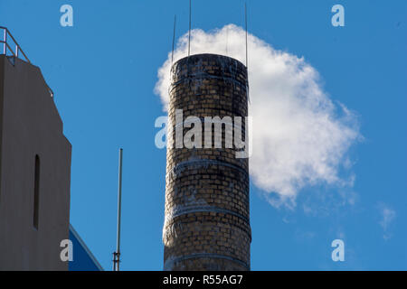 Dampf steigt aus einem gemauerten Schornstein in Brooklyn gegen eine klare Bue sky Stockfoto