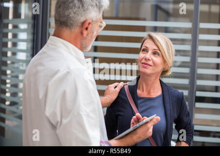 Arzt für Allgemeinmedizin mit einem Patienten sprechen. Stockfoto