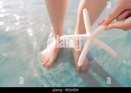 Frau mit Seestern am Strand Stockfoto