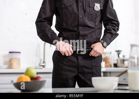 7/8-Ansicht des Polizeibeamten steht neben der Küche Stockfoto