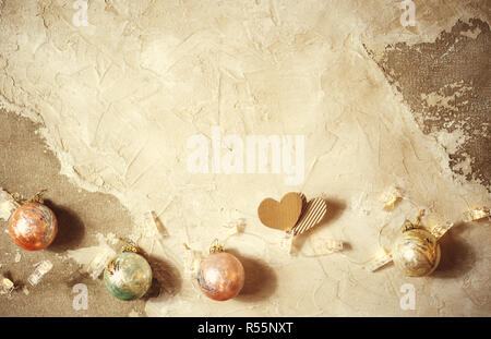 Schneiden Sie Herzen auf grunge Textur Tabelle mit Weihnachtskugeln Stockfoto