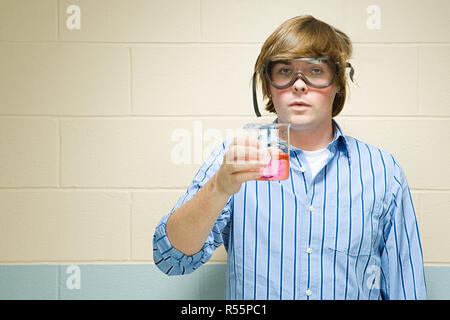 Männliche Schüler halten in Kolben chemische Stockfoto
