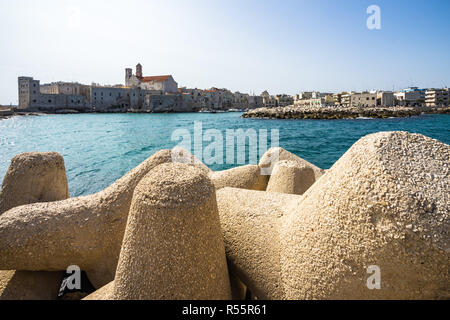 Konkrete Wellenbrecher Barriere in Giovinazzo mit der Altstadt im Vordergrund, Apulien, Italien Stockfoto