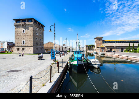 Bunte Canal in Cervia mit San Michele Turm auf der linken Seite und den Salt Museum auf der rechten Seite. Cervia, Emilia Romagna, Italien, August 2017 Stockfoto
