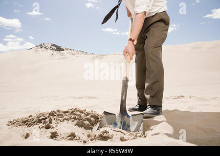 Man gräbt in Wüste Stockfoto