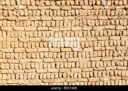 Alten islamischen arabischen muslimischen Altstadt Haus Mauer gebaut von gelb braun Lehmziegeln an einem sonnigen Tag Textur. Al Qasr, Dakhla Oase, Western Desert, Ägypten. Stockfoto