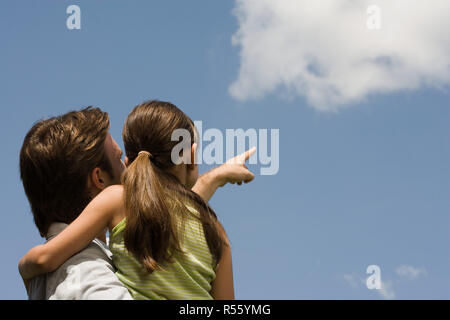 Vater und Tochter auf der Suche auf Wolke Stockfoto