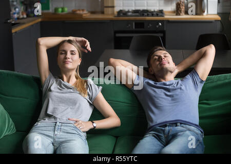 Junger Mann und Frau sitzen zusammen auf der Couch, entspannend Stockfoto