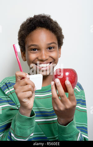 Boy Holding Apple und Zahnbürste Stockfoto