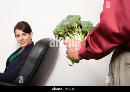 Mann hält eine Reihe von Brokkoli Stockfoto