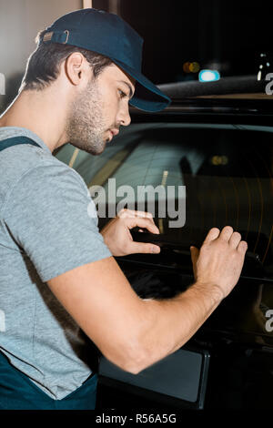 Junge konzentrierte Handwerker Kontrolle Automobil Details an Mechaniker shop Stockfoto