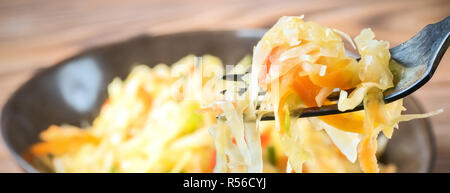 Salat Vorspeise von fermentierten Gemüse Sauerkraut Karotten und Paprika in Schale und auf die Gabel. Konzept trend Diät Nahrung Vegetarische Rezepte bis zu hausgemachten Stockfoto