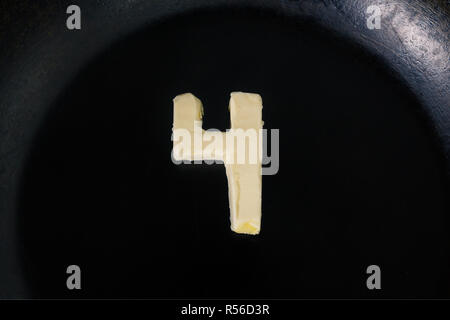 Butter in Form der Zahl 4 auf heiße Pfanne - Nahaufnahme, Ansicht von oben Stockfoto