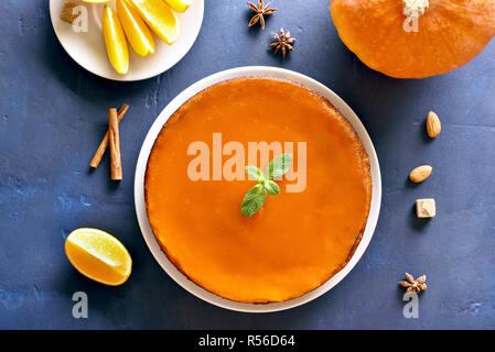 Lecker Kürbis und Orange Torte auf blauen Stein. Traditionelle herbst Gericht. Gesunde vegetarische Nahrung. Ansicht von oben, flach Stockfoto