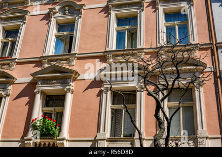 Architektonische Elemente des alten Wohnhauses in der Innenstadt von Prag, Tschechische Republik, chemische toten Ästen und blühende rote Blumen auf dem Balkon Stockfoto