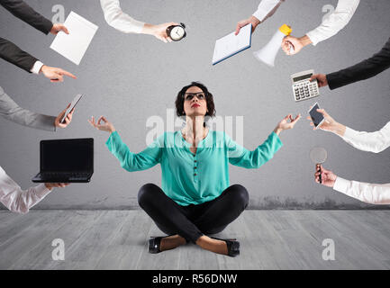 Geschäftsfrau versucht mit Yoga durch Stress Ruhe zu behalten und im Wok Überarbeitung Stockfoto