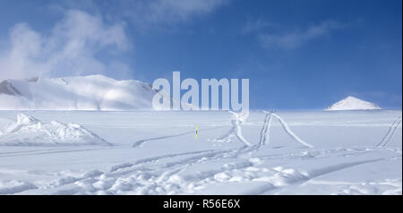 Panoramablick auf Off-piste Skipiste mit neuen - Schnee und Spuren von Skiern, Snowboards gefallen nach Schneefall. Kaukasus Berge im Nebel bei Sun winter Ev Stockfoto
