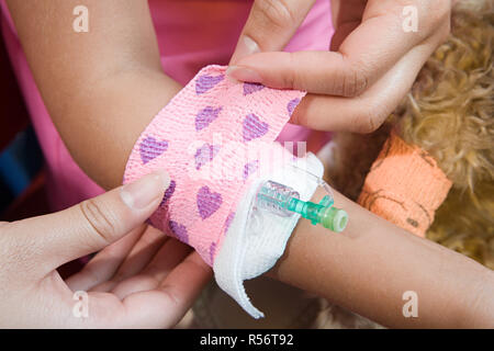 Mädchen mit Bandage um Katheter gelegt Stockfoto