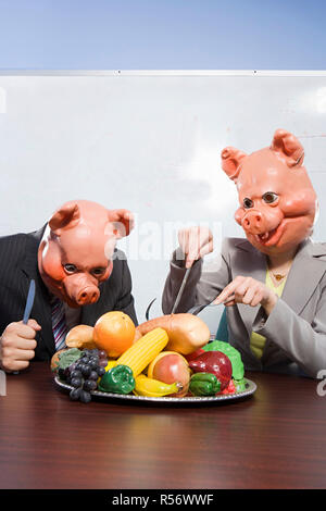 Geschäftsleute in Schwein Masken mit Kunststoff-Lebensmittel Stockfoto