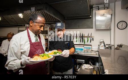 Us-Staatssekretär für Wohnungswesen und Stadtentwicklung Ben Carson, Links, hilft mit, das Thanksgiving Mittagessen in Christus Haus November 20, 2018 in Washington, DC. Stockfoto