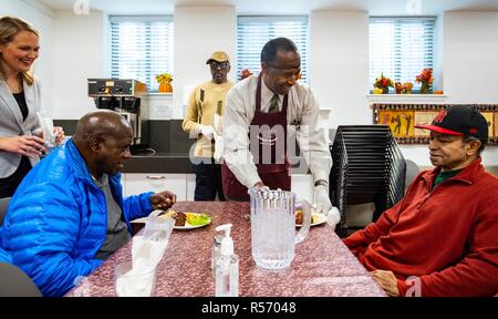 Us-Staatssekretär für Wohnungswesen und Stadtentwicklung Ben Carson spricht mit Bewohner nach helfen Thanksgiving Mittagessen in Christus Haus November 20, 2018 in Washington, DC. Stockfoto