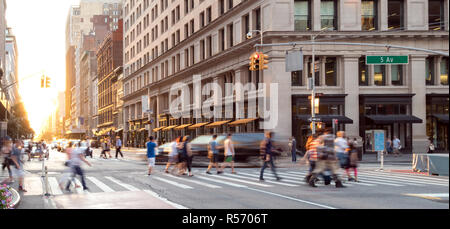 New York City street scene mit Massen von Menschen zu Fuß durch die belebten Kreuzung der 23. und 5. Avenue in Midtown Manhattan Stockfoto