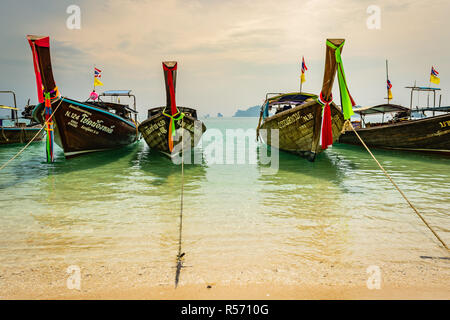 KRABI, THAILAND - NOVEMBER 2018: traditionelle thailändische Boote aus Holz mit Band Dekoration an der Küste in der Nähe von Krabi, Thailand Stockfoto