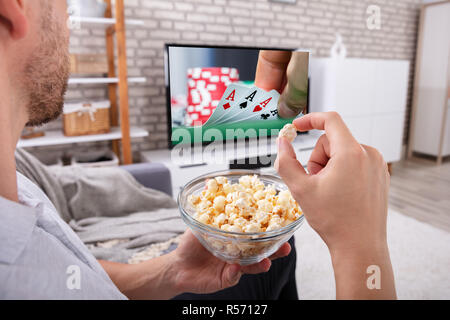 Close-up von einem Mann mit Schüssel Popcorn Fernsehen zu Hause Stockfoto